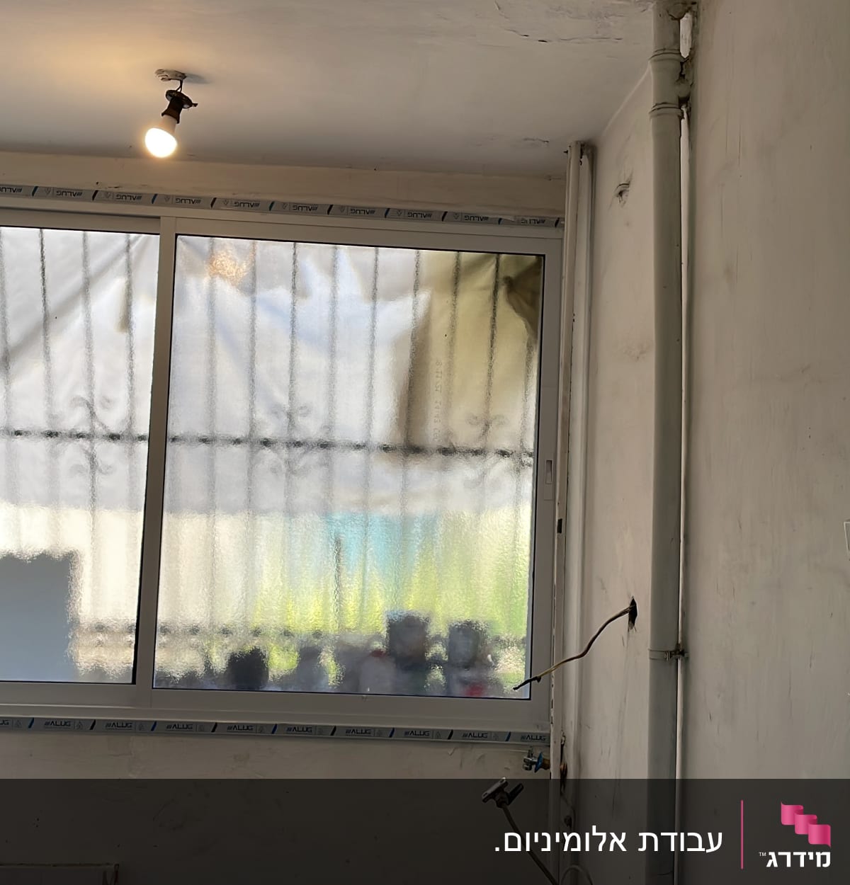 חלון אלומיניום עם מסגרת לבנה וקיר לבן